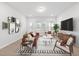 Living room features a brown leather couch and wood furniture, large windows at 2790 Farmhouse Dr, Apex, NC 27502