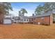 Backyard featuring a brick home, shed, and mature trees at 302 S Pine St, Benson, NC 27504