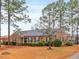 Charming brick home featuring manicured front yard with mature trees at 302 S Pine St, Benson, NC 27504