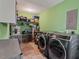 This laundry room features modern washer and dryer units, shelves for storage, and a pet gate at 302 S Pine St, Benson, NC 27504