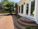 A brick patio with brick steps leading up to the side of the house, with large glass windows and doors at 307 Westfield Dr, Dunn, NC 28334