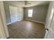 Bright bedroom with wood-look flooring and double doors leading to a spacious closet at 307 Westfield Dr, Dunn, NC 28334