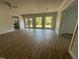 A living room with hardwood floors, three windows, double glass doors, and white brick walls at 307 Westfield Dr, Dunn, NC 28334