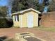 Yellow storage shed with blue shutters in the backyard at 307 Westfield Dr, Dunn, NC 28334