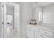 Bright bathroom with a large mirror, white cabinets, and a view through the doorway to the bedroom at 3400 Amelia Grace Dr # 46, Fuquay Varina, NC 27526