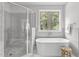 Bathroom featuring soaking tub by window, and walk-in shower for a spa-like experience at 3400 Amelia Grace Dr # 46, Fuquay Varina, NC 27526