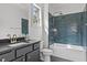Stylish bathroom with blue tiled shower and tub combo, complemented by a sleek black vanity at 3400 Amelia Grace Dr # 46, Fuquay Varina, NC 27526