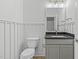 Half bathroom featuring stylish vanity with dark countertop and grey cabinets, complemented by wood-look flooring at 3400 Amelia Grace Dr # 46, Fuquay Varina, NC 27526