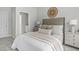 Neutral bedroom featuring plush bedding and a woven decor piece, complemented by an ensuite bath through an open doorway at 3400 Amelia Grace Dr # 46, Fuquay Varina, NC 27526