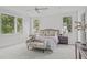 Bright main bedroom with large windows, plush carpet, and elegant furnishings offers a serene retreat at 3400 Amelia Grace Dr # 46, Fuquay Varina, NC 27526