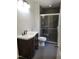 Modern bathroom with a dark wood vanity and a tiled shower with glass doors at 4300 Hickory Ridge Dr, Raleigh, NC 27609