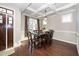 Elegant dining room with a coffered ceiling, chandelier, and a dark wood table with leather chairs at 4538 Brighton Ridge Dr, Apex, NC 27539