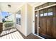 Inviting front porch with wood flooring, a dark wood door with glass panes, and stone pillar bases at 4538 Brighton Ridge Dr, Apex, NC 27539