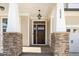 Charming entryway with a dark wood door, stone accents, and craftsman-style columns at 4538 Brighton Ridge Dr, Apex, NC 27539
