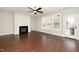 Bright living room featuring hardwood floors, a fireplace, ceiling fan, and large windows offering lots of natural light at 4538 Brighton Ridge Dr, Apex, NC 27539
