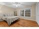 Comfortable bedroom with hardwood floors, large windows, and ceiling fan at 4908 Winterlochen Rd, Raleigh, NC 27603