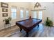 Game room features a pool table, hardwood floors, and large windows at 5240 Indigo Moon Way, Raleigh, NC 27613