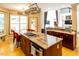 Open concept kitchen with a large island, cooktop, stainless steel oven, and access to screened in porch at 5240 Indigo Moon Way, Raleigh, NC 27613
