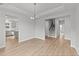 Open dining room with hardwood floors, kitchen view, and stairs at 529 Ravensworth Dr, Garner, NC 27529