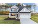 Two-story house with gray siding, white garage door, and landscaping at 529 Ravensworth Dr, Garner, NC 27529