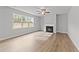 Living room with wood-look floors, fireplace, and ceiling fan at 529 Ravensworth Dr, Garner, NC 27529