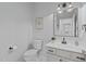 Clean bathroom with toilet, vanity, mirror, and modern lighting fixtures at 105 Fountain Ridge Pl, Holly Springs, NC 27540