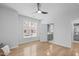 Bright bedroom featuring light wood floors, a ceiling fan, and ample natural light from two large windows at 105 Fountain Ridge Pl, Holly Springs, NC 27540