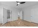 Bright bedroom featuring light wood floors, a ceiling fan, and ample natural light from two large windows at 105 Fountain Ridge Pl, Holly Springs, NC 27540