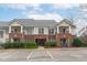 Attractive building exterior with brick accents, covered balconies, and manicured landscaping at 105 Fountain Ridge Pl, Holly Springs, NC 27540