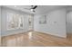 Well-lit empty room featuring hardwood floors, neutral paint, ceiling fan, and a door to an outdoor patio at 105 Fountain Ridge Pl, Holly Springs, NC 27540