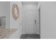 Clean hallway features a round mirror, tile flooring, and white walls, creating a welcoming entry at 105 Fountain Ridge Pl, Holly Springs, NC 27540