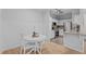 Bright kitchen features a white dining set, stainless steel appliances, granite countertops and natural wood flooring at 105 Fountain Ridge Pl, Holly Springs, NC 27540