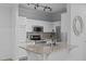 Modern kitchen with stainless steel appliances, white cabinetry, speckled granite countertops, and a stylish kitchen island at 105 Fountain Ridge Pl, Holly Springs, NC 27540
