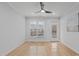 Sunlit living room with hardwood floors, a ceiling fan, and balcony access at 105 Fountain Ridge Pl, Holly Springs, NC 27540