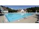 Community swimming pool featuring a large pool with lounge chairs and umbrellas for residents' enjoyment at 105 Fountain Ridge Pl, Holly Springs, NC 27540