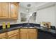 Modern kitchen with wood cabinets, granite counters, and black appliances at 118 Talon Dr, Cary, NC 27518