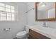 Simple bathroom with brown vanity and a framed mirror at 1200 Rogers Rd, Graham, NC 27253