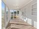 Sunroom with windows, built-in shelving, and wood-look flooring at 1200 Rogers Rd, Graham, NC 27253