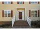 House entrance with red door, brick steps and white railings at 1216 Magnolia Hill Rd, Garner, NC 27529