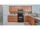 Well-equipped kitchen with wood cabinets and black appliances at 1316 Holly Grove Way, Durham, NC 27713