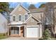 Two-story tan house with white shutters, a white door and a two-car garage at 152 Brentfield Loop, Morrisville, NC 27560