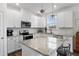 Modern kitchen with white cabinets, granite island, and stainless steel appliances at 233 John Stark Dr, Fuquay Varina, NC 27526
