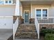 Stone steps leading to a gray front door with white railings at 312 Lucky Ribbon Ln, Holly Springs, NC 27540