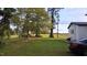 Lush backyard featuring mature trees and a well-maintained lawn, providing a serene outdoor space at 3259 Us 421, Lillington, NC 27546