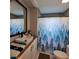 Cozy bathroom featuring a white vanity, modern sink, and a bathtub with a blue and white tree-themed shower curtain at 3259 Us 421, Lillington, NC 27546