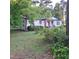 Charming white ranch home with red door and mature trees at 3259 Us 421, Lillington, NC 27546