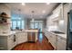 White kitchen with stainless steel appliances and hardwood floors at 404 Stearns Way, Wake Forest, NC 27587