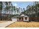 Modern farmhouse exterior, featuring a white exterior, brown accents, and a large yard at 4120 Emily Ln, Oxford, NC 27565