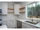 Modern kitchen features white cabinets, marble countertops, and wood floating shelves at 4120 Emily Ln, Oxford, NC 27565