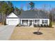 Beautiful white home featuring a welcoming front porch and well-maintained landscaping at 430 Heart Pine Dr, Wendell, NC 27591